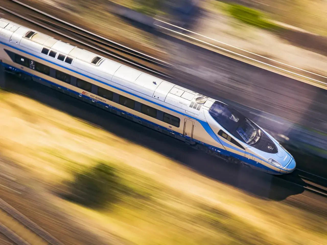 Nowoczesny pociąg PKP Intercity Pendolino na tle krajobrazu