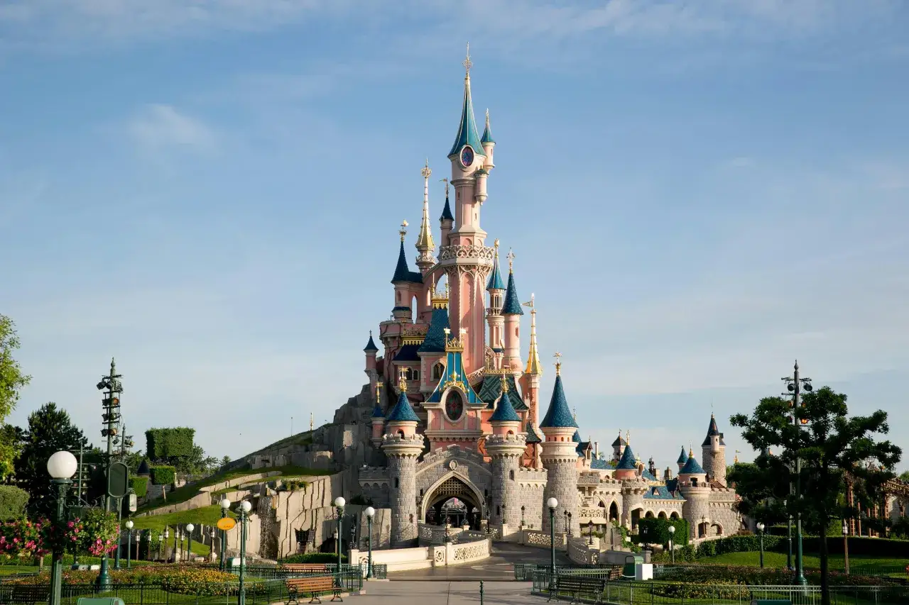 Dorośli w Disneyland Paris na tle Zamku Śpiącej Królewny